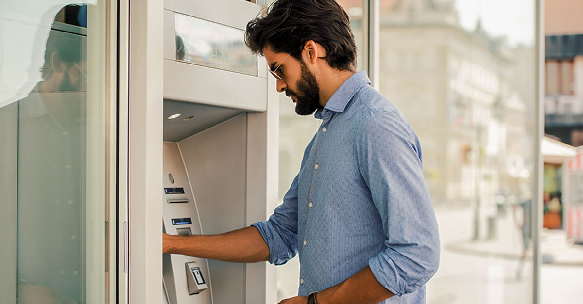 Foto mostra homem sacando em caixa rápido de banco