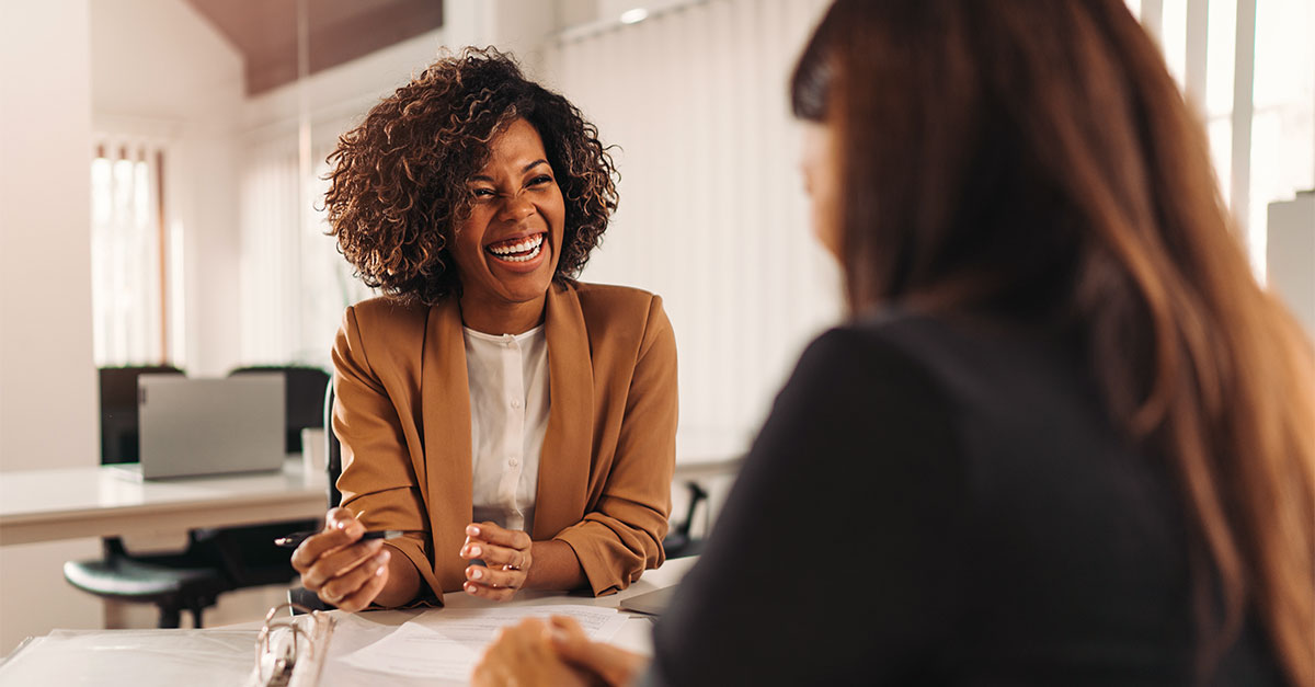 Foto mostra duas mulheres negociando em uma mesa